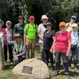 Hikers at the 0.0 km marker in St Marys after the End to End Hike July 5
